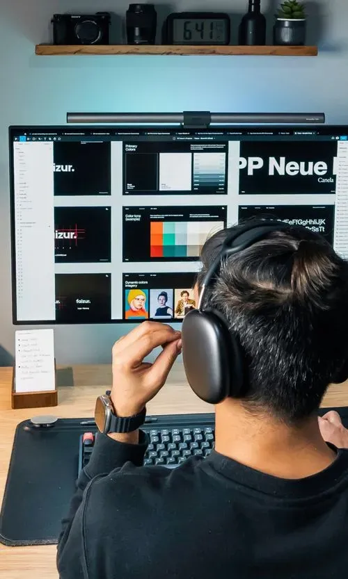 Faizur designing on a large monitor